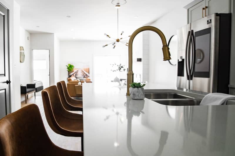 A modern kitchen showing centre island with ornate brass taps.