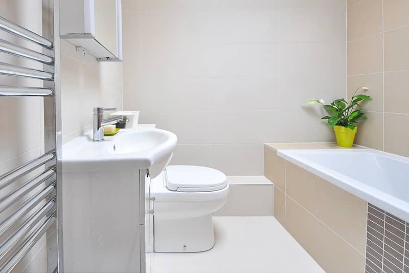 A modern bathroom with white bath, sink and toilet units.